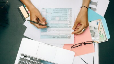 Computer, Steuerformular, Brille und Geldscheine